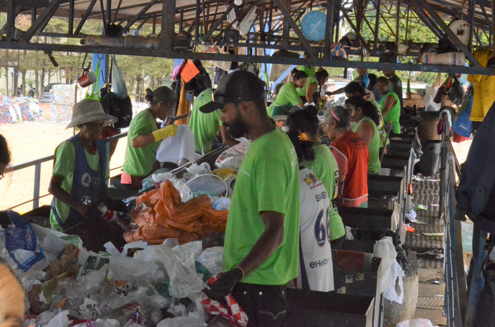 Trabalhadores em uma cooperativa de reciclagem separando materiais em uma esteira